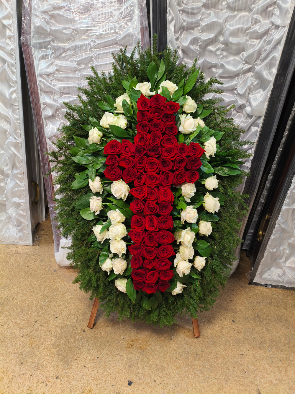 Траурный венок из живых красных и белых роз в форме креста