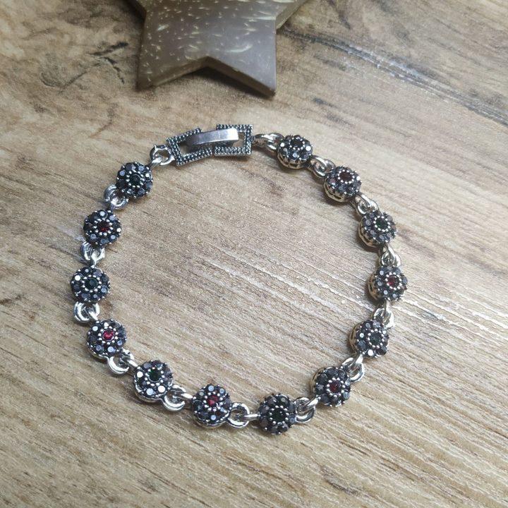 Браслет Vogue Цветочек стразы графитовые зеленые красные металл серебристый на красном бархате