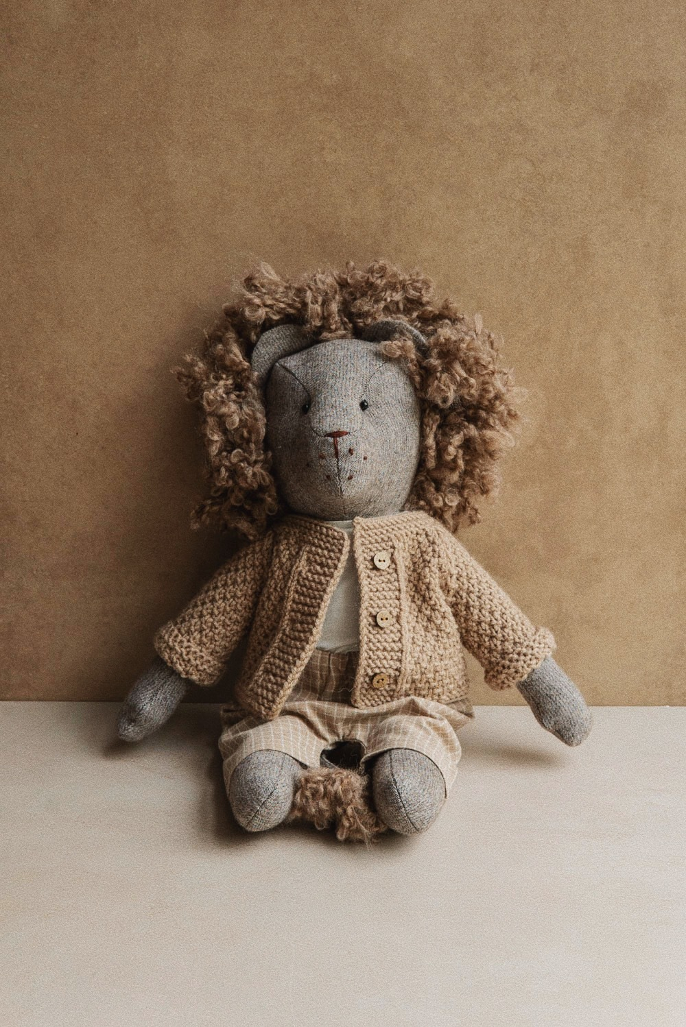 Лев в бежевом кардигане