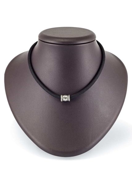 Фотография шарма Наутиз из серебра 925 пробы на постаменте.