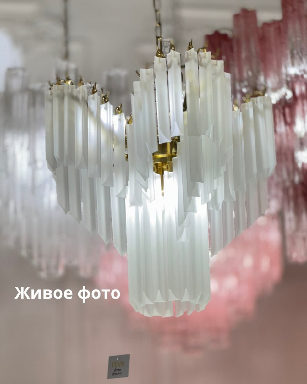 Изысканная каскадная люстра с вытянутыми стеклянными элементами и декоративной потолочной розеткой.