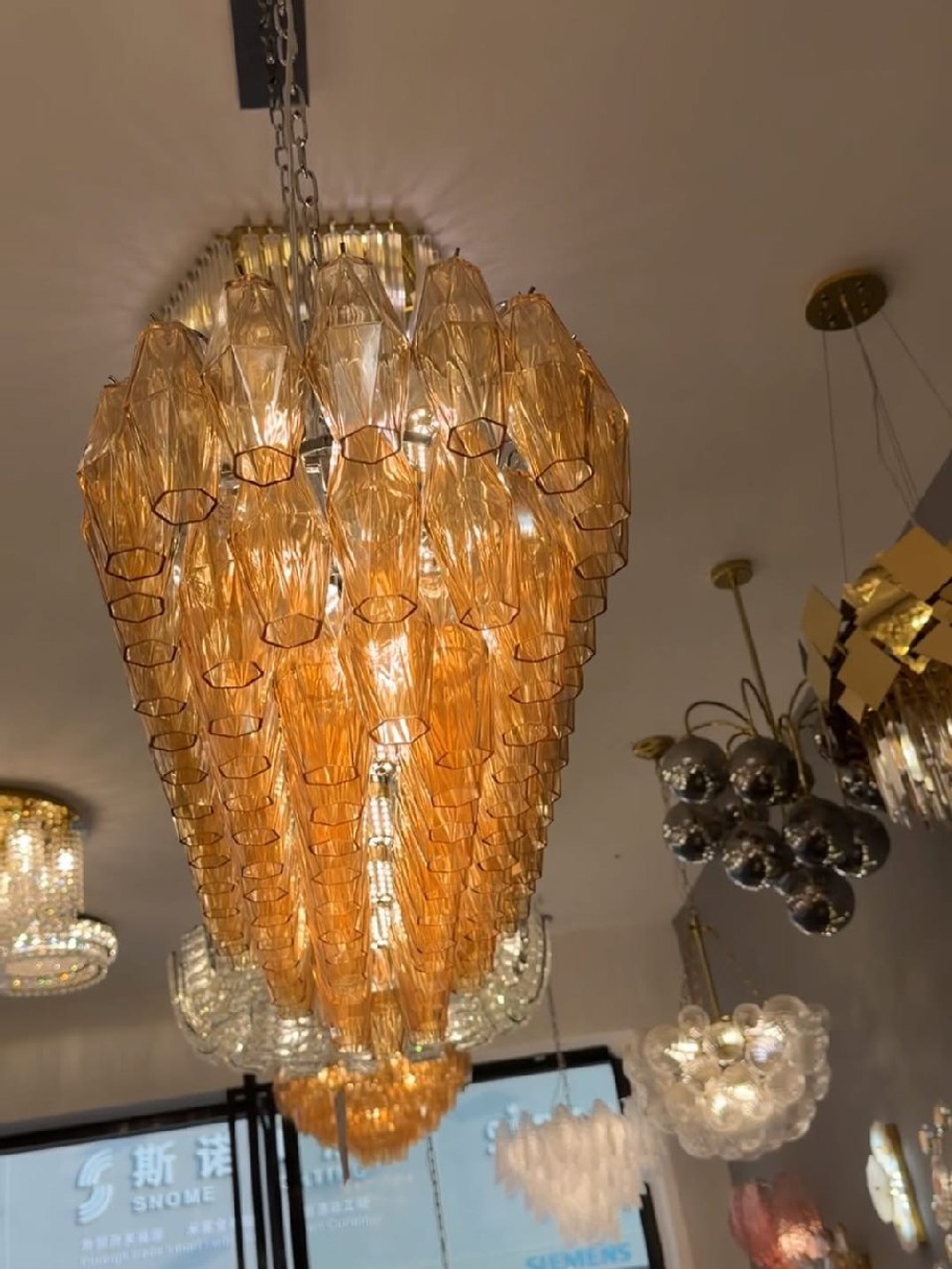 Эффектная люстра с множеством рифлёных стеклянных плафонов янтарного оттенка на золотом основании ✨