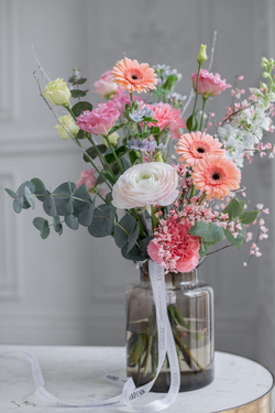 Яркий букет с ранункулюсами и оранжевыми герберами.