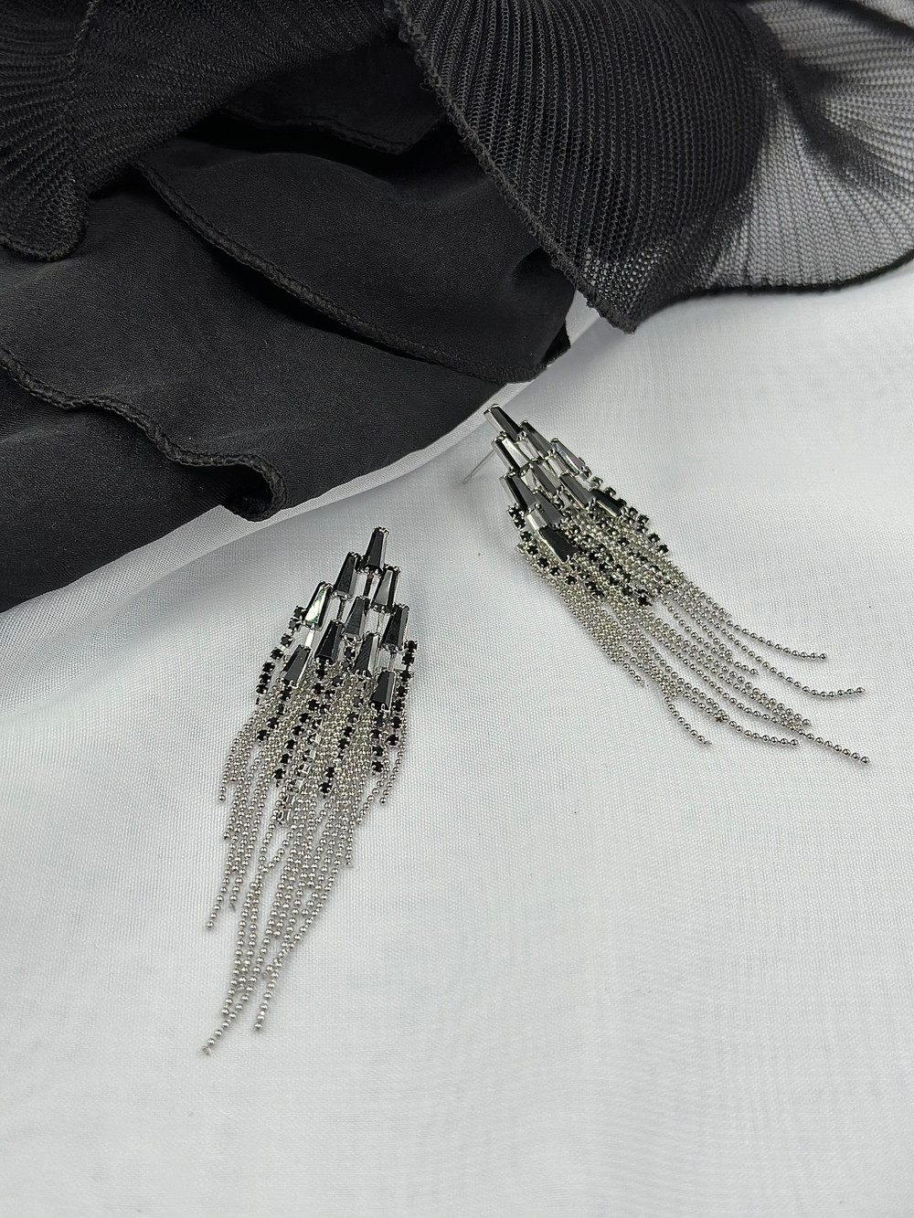 Серьги в темными кристаллами в шахм.порядке и длинными цепочками из шариков, оттенок серебро