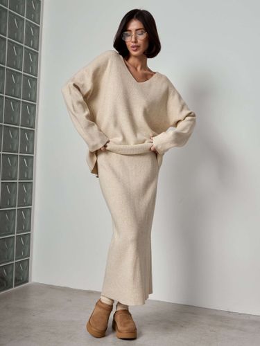 Бежевый трикотажный костюм с юбкой