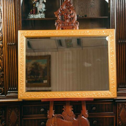 Настенное зеркало в золотой раме