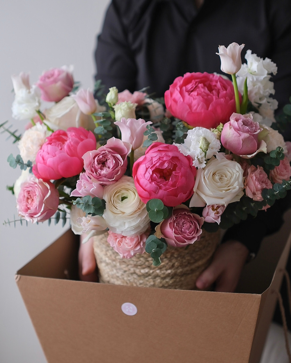 Корзина с пионами Корал Шарм, ранункулюсами и пионовидными розами Пинк Монстр