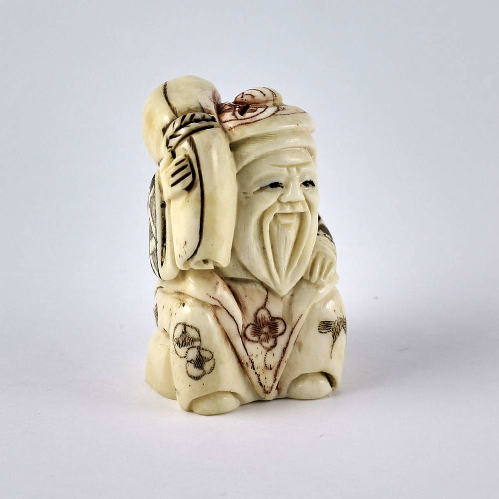 Нэцкэ Дзюродзин в круглой шапке и с ковром на плече