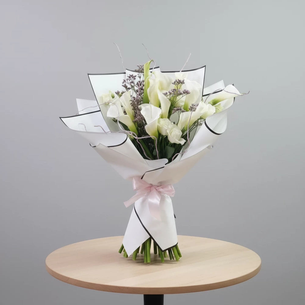 Букет из 15 калл на столе.