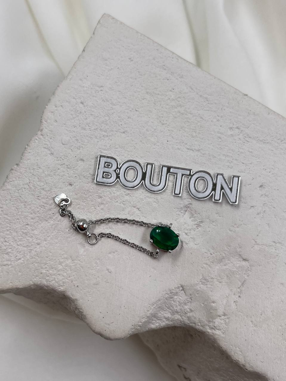 Кольцо серебристое на цепочке с зеленым стразом