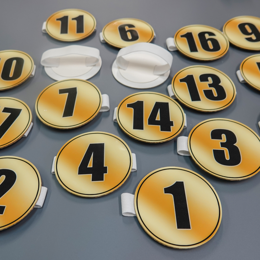 Номер участника, крепление в ассортименте. Диаметр 86 мм. Шрифт черный.