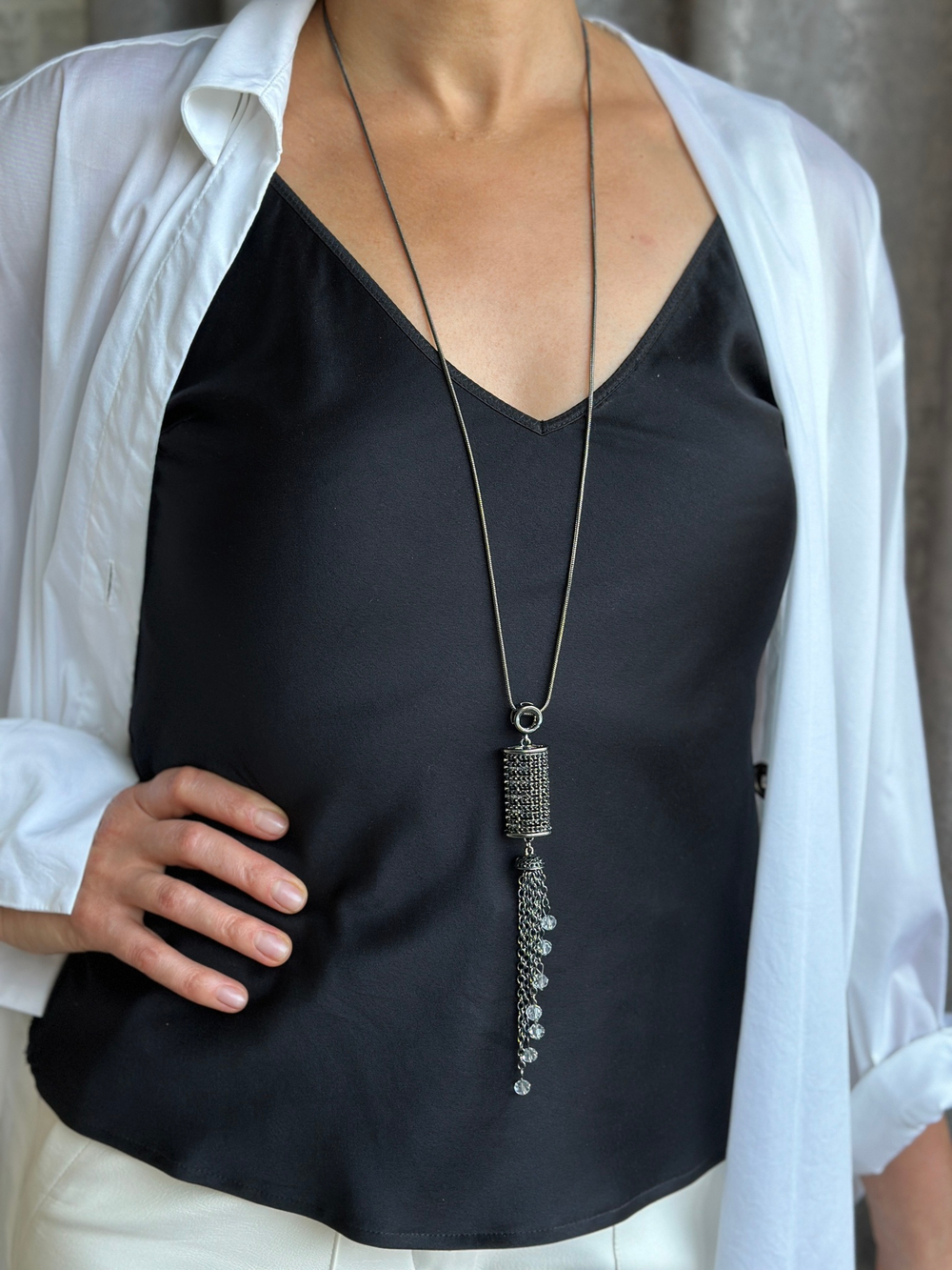 Кулон на длинной цепочке с черными и серыми кристаллами.