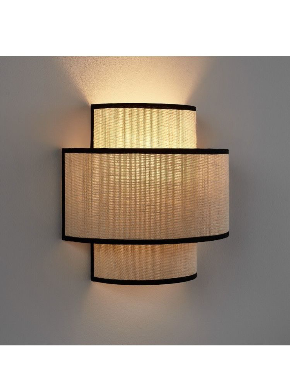 Стильное настенное бра с многоуровневым абажуром из натурального текстиля.