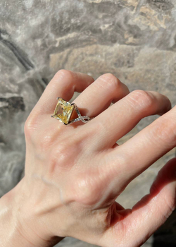 Серебряное кольцо с желтым фианитом квадратной формы и белыми микроцирконами на шинке добавит нотку элегантности в ваш образ. Носите его со стилем Casual или строгим деловым костюмом – изделие придаст яркости любому гардеробу. Украшение произведено из гипоаллергенного и высокопрочного серебра 925-й пробы, следовательно, не причинит дискомфорта. Купить кольцо с желтым фианитом квадратной формы и белыми микроцирконами на шинке можно в нашем ювелирном магазине по доступной цене. Изделие доставляется как по Москве, так и всей территории РФ.