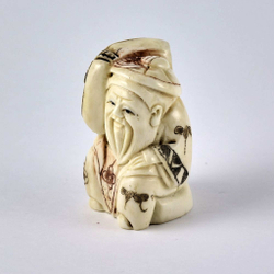 Нэцкэ Дзюродзин в круглой шапке и с ковром на плече