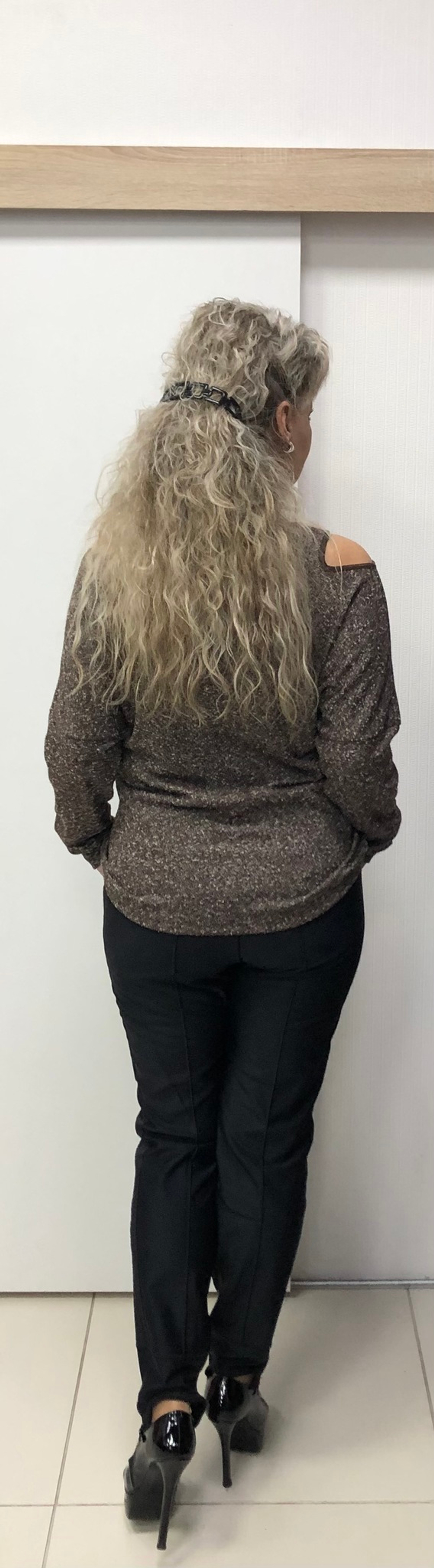 Бежево-коричневый джемпер со стразовой отделкой по груди и вырезами по плечам.