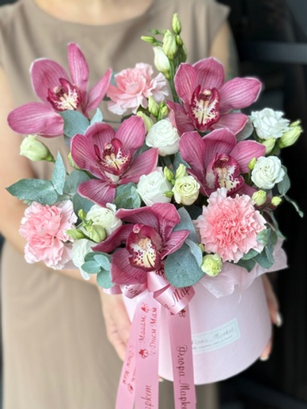 Нежная композиция с цимбидиумом, диантусом, эустомой и эвкалиптом в шляпной коробке от Флора Маркет