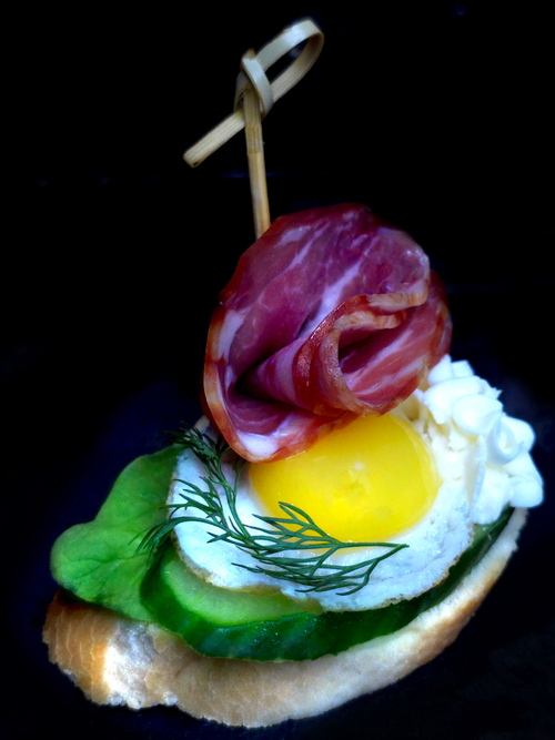 Брускетт с копчёной свиной шейкой, перепелиным яйцом и сливочным сыром