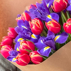 Букет весенний пионовидных тюльпанов и синих ирисов в крафте