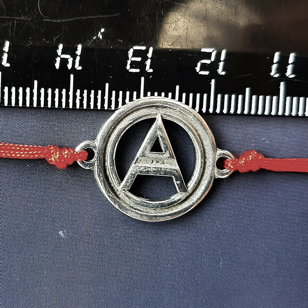 Красная нить с оберегом Символ Велеса. Диаметр кулона 15 мм. Материал Пьютер (английское серебро)