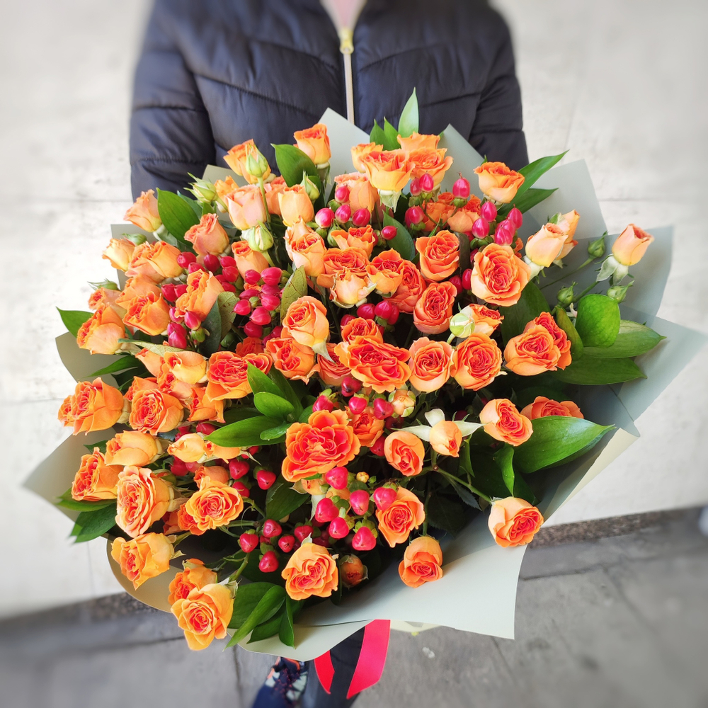 Букет из 17 оранжевых кустовых роз с гиперикумом