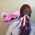 Нежный розовый букет из мини Гербер в упаковке с зеленью