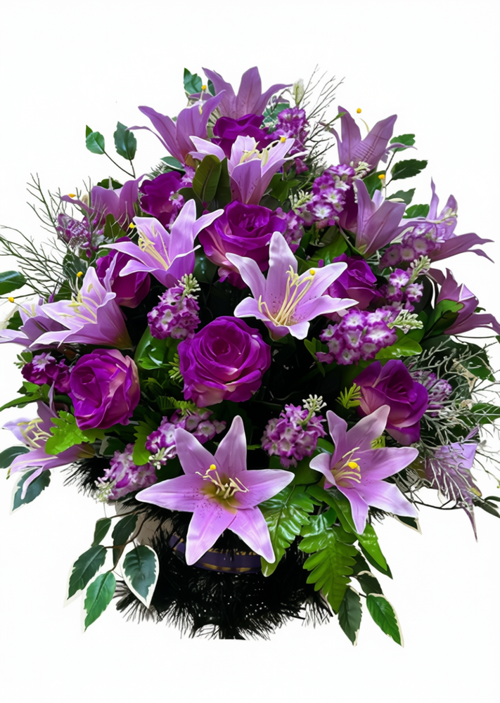Корзина из искусственных цветов: фиолетовые лилии, розы и мелкие цветы, дополненные зеленью.
