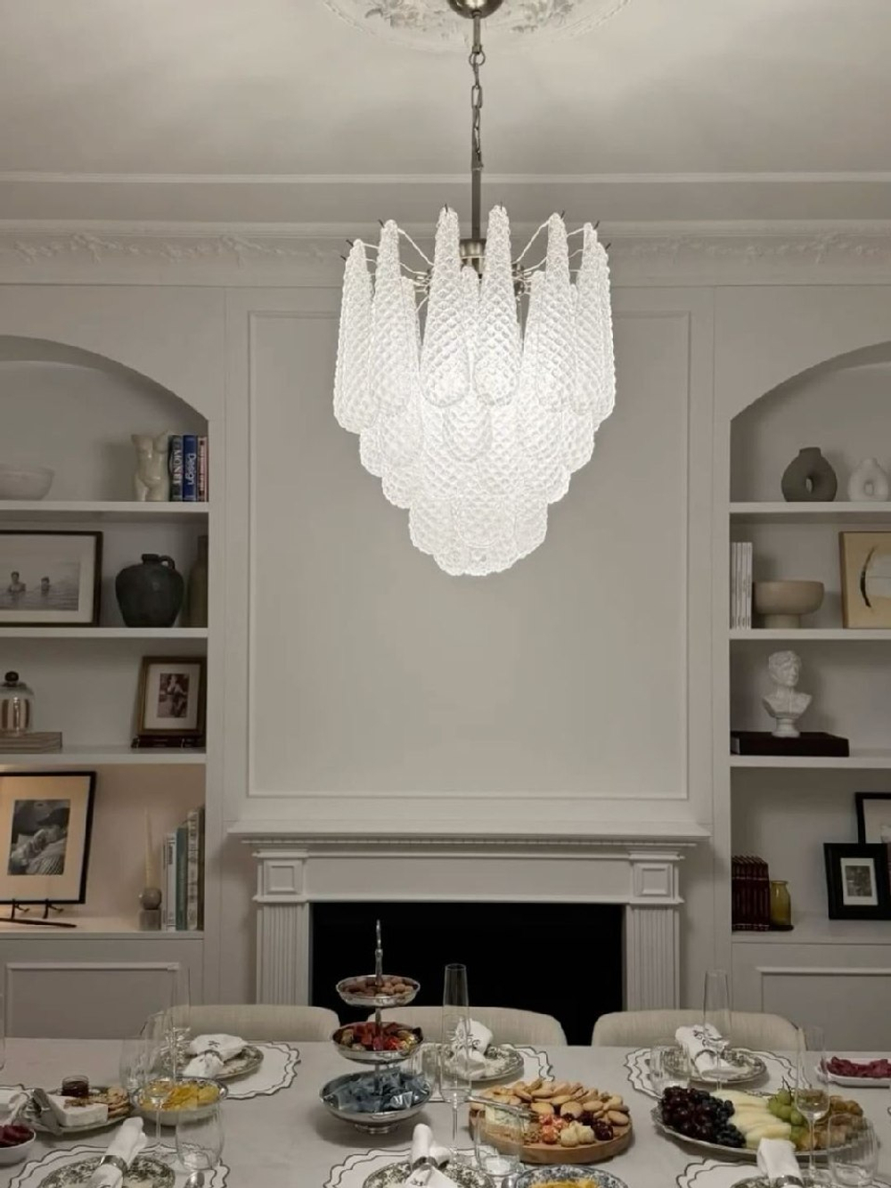 Элегантная подвесная люстра с металлическим каркасом и каскадом фактурных стеклянных плафонов.