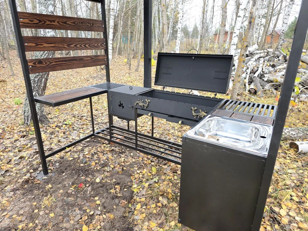 Мангальная зона из стали 5 мм с мойкой (Казань) Если вы хотите купить мангальную зону с мойкой в Казани, присмотритесь к нашему варианту: это мангальная зона 5 мм с крышей (полноценная уличная кухня/зона барбекю), где есть мангал 5 мм с жаровней 90×40×15 (рассчитан примерно на 11 шампуров), крышка барбекю с термодатчиком и шиберами для удобной регулировки тяги и температуры. Также зону можно использовать как коптильню — коптить рыбу, мясо и курицу.  Отдельно предусмотрена печь под казан 5 мм размером 40×40×30 с кольцами под казаны 3/4/6/8/10/12 литров, есть труба 80×80 с заслонкой, колосник и зольник. Для удобства сделаны столик для нарезки (стол металл+дерево), нержавеющая мойка 48×48, дровница и тубус для шампуров. Конструкция разборная, собирается на болтовых соединениях. Зона может быть в наличии в Казани, доступна доставка и установка, а также изготовление мангальной зоны под заказ под ваши размеры.