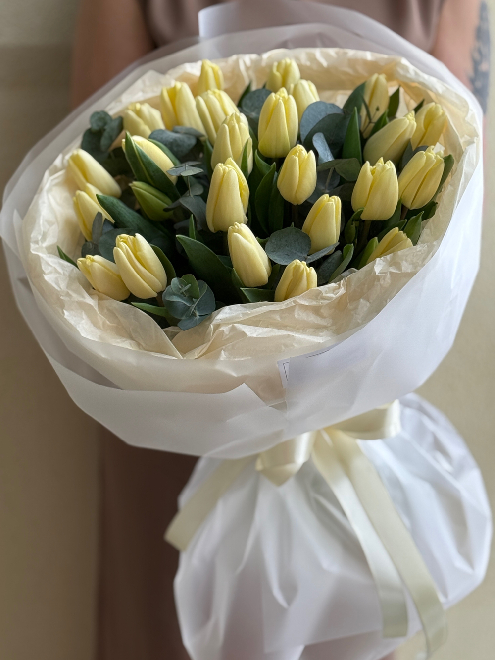Кремовые тюльпаны и зелень эвкалипта в нежном оформлении Флора Маркет
