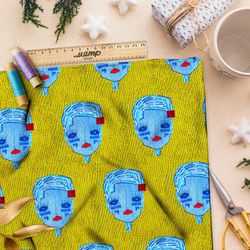 Ткань атлас синие кукольные головы на жёлтом фоне