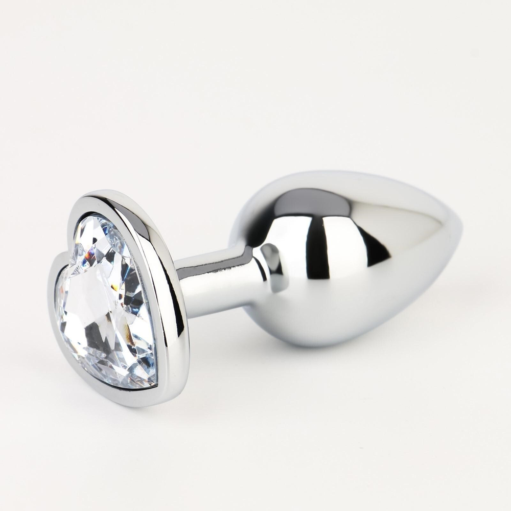 Серебристая анальная пробка с прозрачным кристаллом в форме сердца - 7 см. (Цвет: серебристый)