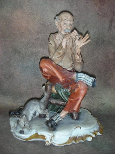 Статуэтка. Фарфор. Мужчина, зашивающий носок. Capodimonte. Италия