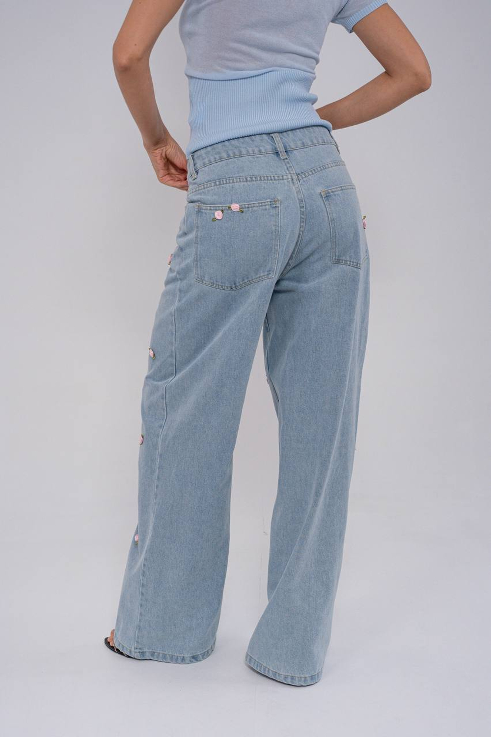 Джинсы широкие , голубые ,с нашивками в виде цветков .