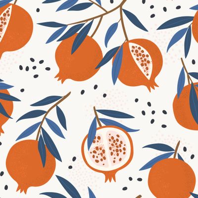 Спелые гранаты с синими листьями на белом фоне