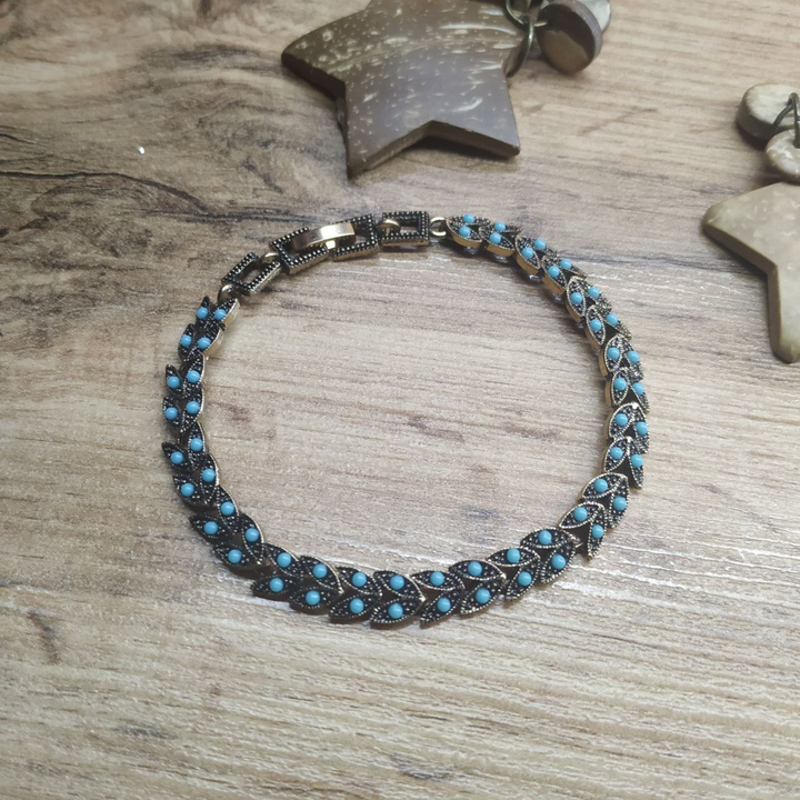 Браслет Vogue Двулистник бусинки голубые металл золотистый на красном бархате