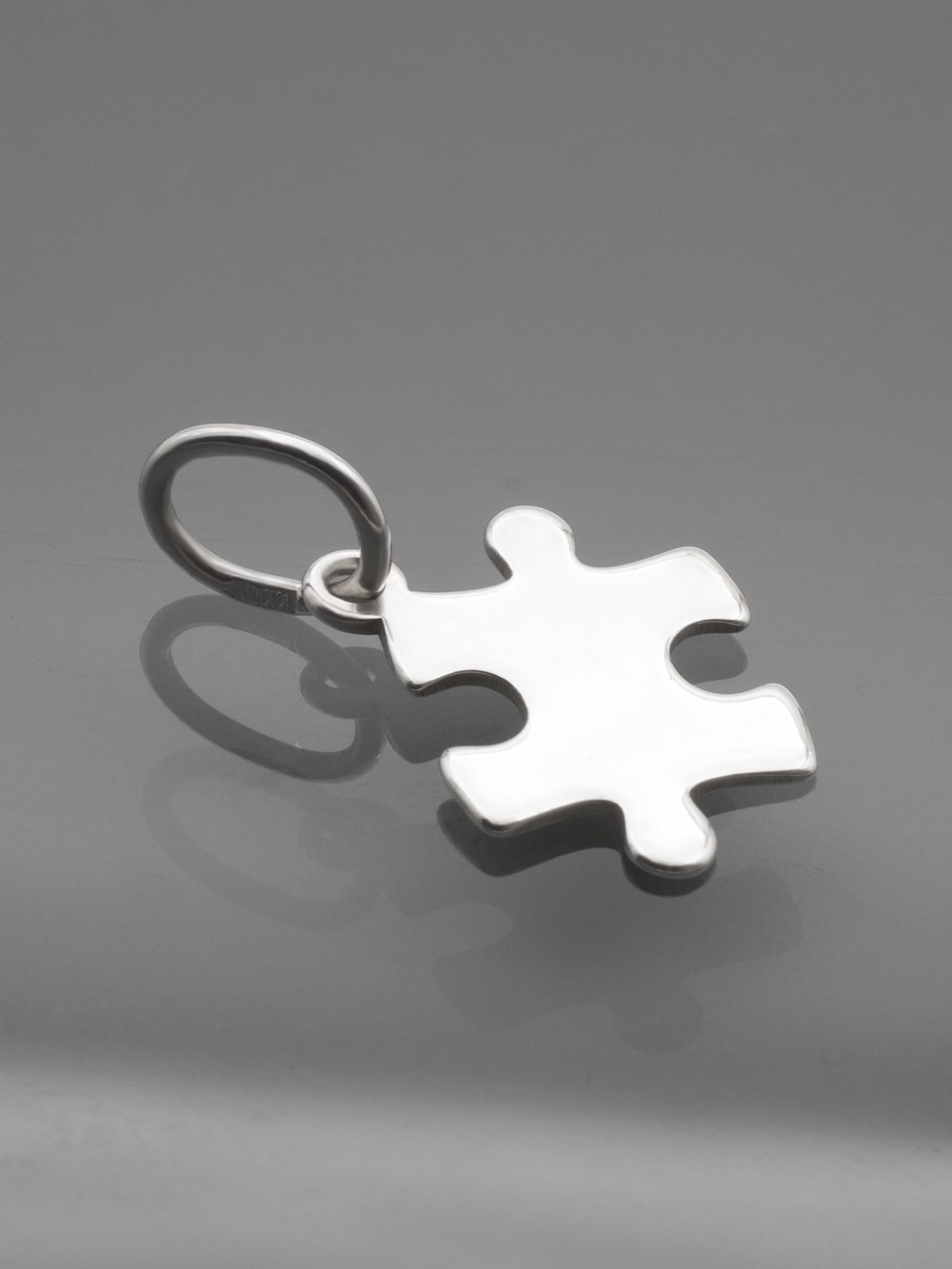 Реальная фотография подвески пазл из серебра на темном фоне