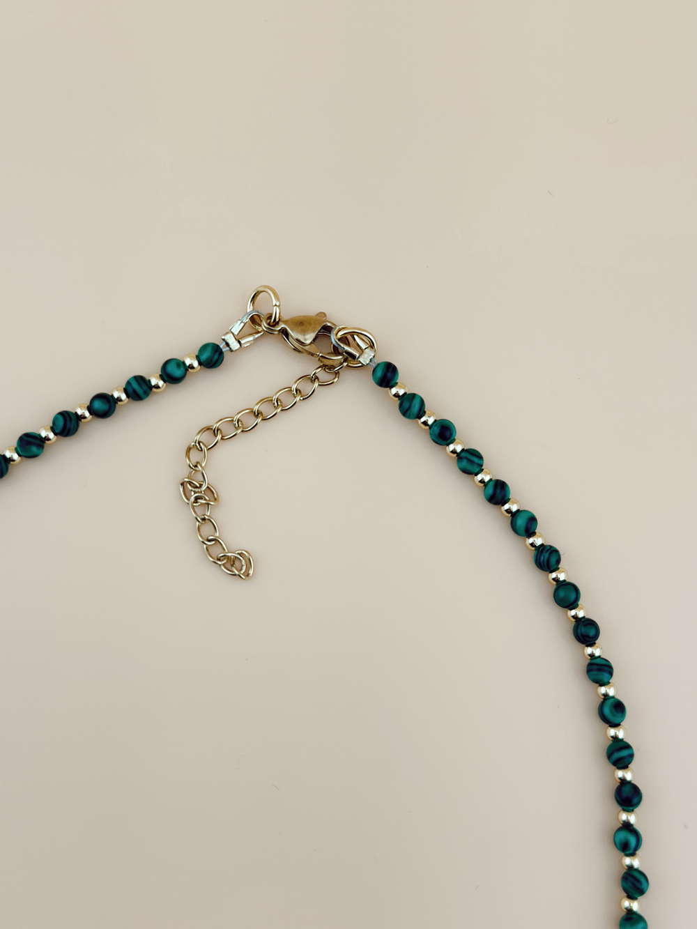 Колье с зелеными шариками и золотым сердечком