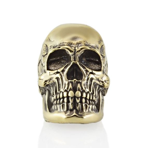 Фото бронзовой бусины Skull Victory в профиль на белом фоне.