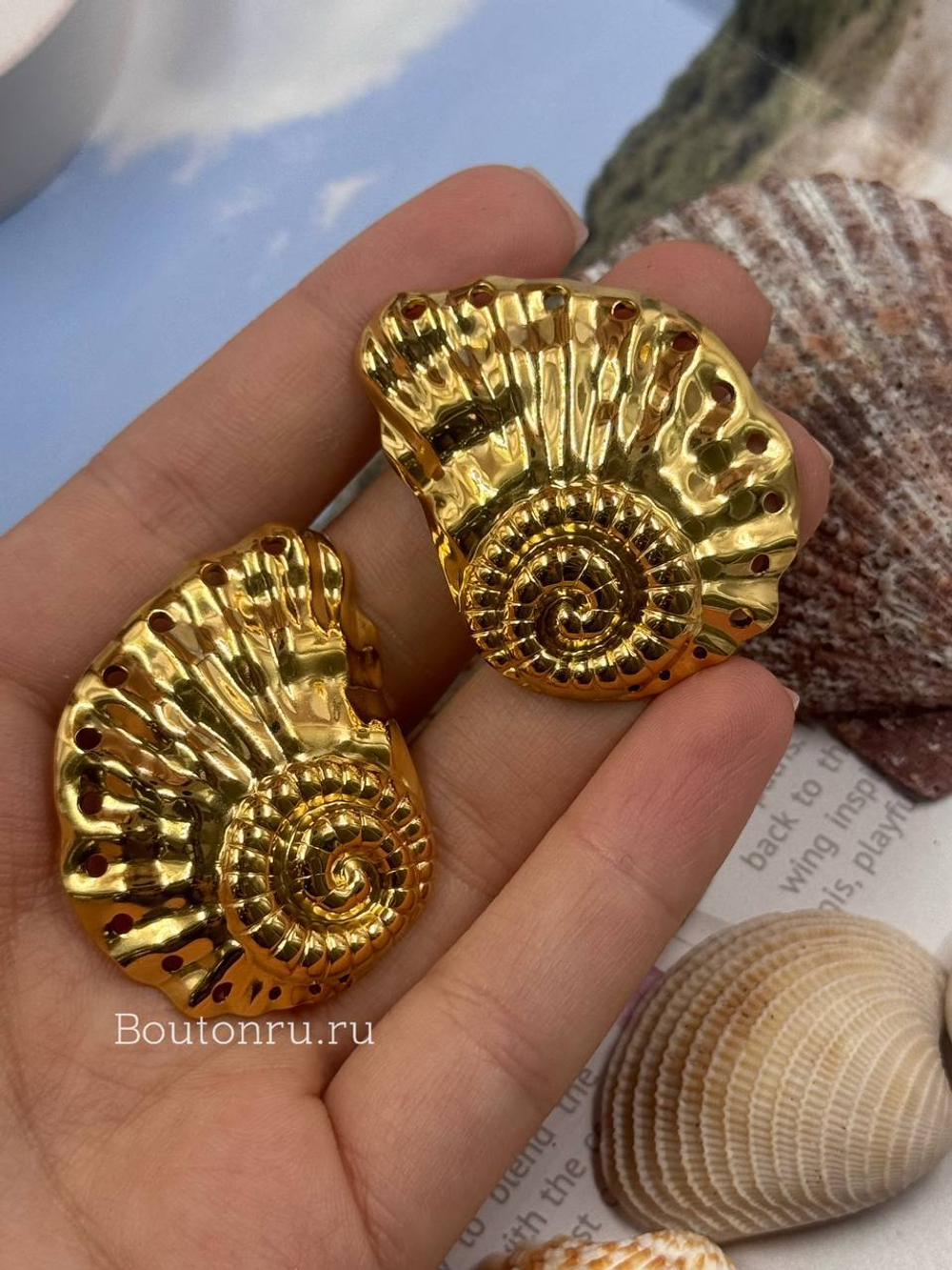 Массивные золотистые серьги в форме ракушки