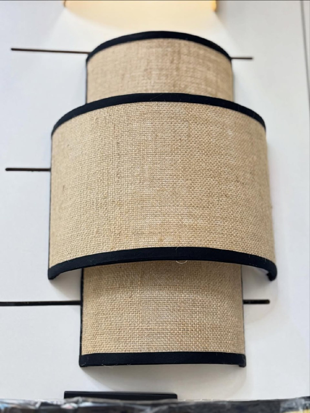 Стильное настенное бра с многоуровневым абажуром из натурального текстиля.