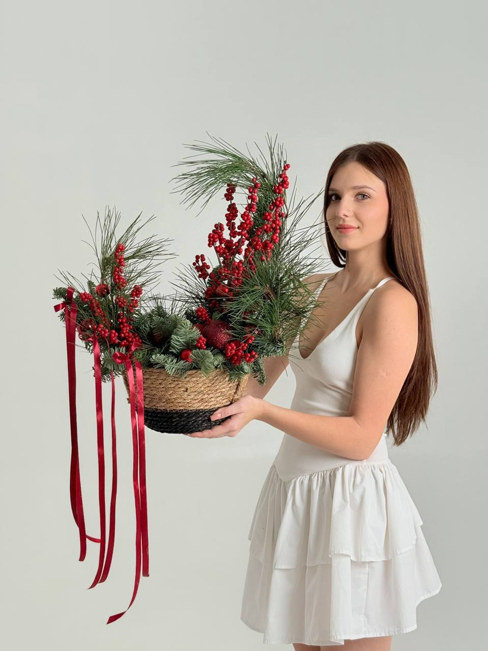 Новогодняя композиция из хвои в корзине с красными лентами