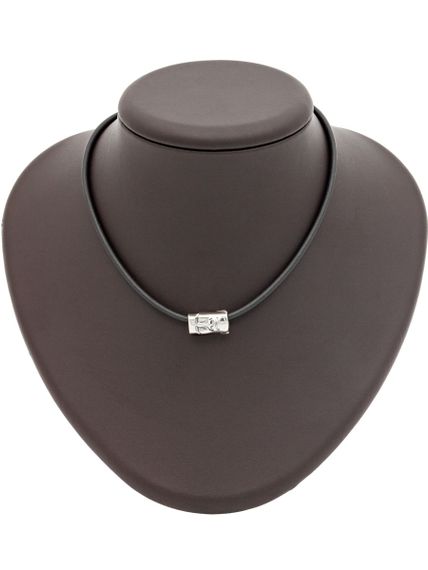 Фото шарма Моаи из серебра на коричневом постаменте.