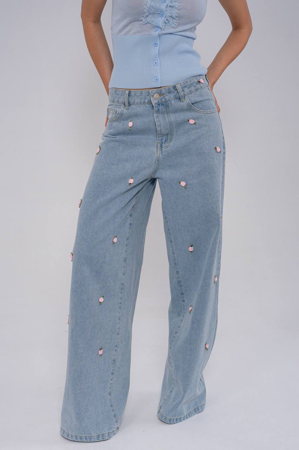 Джинсы широкие , голубые ,с нашивками в виде цветков .