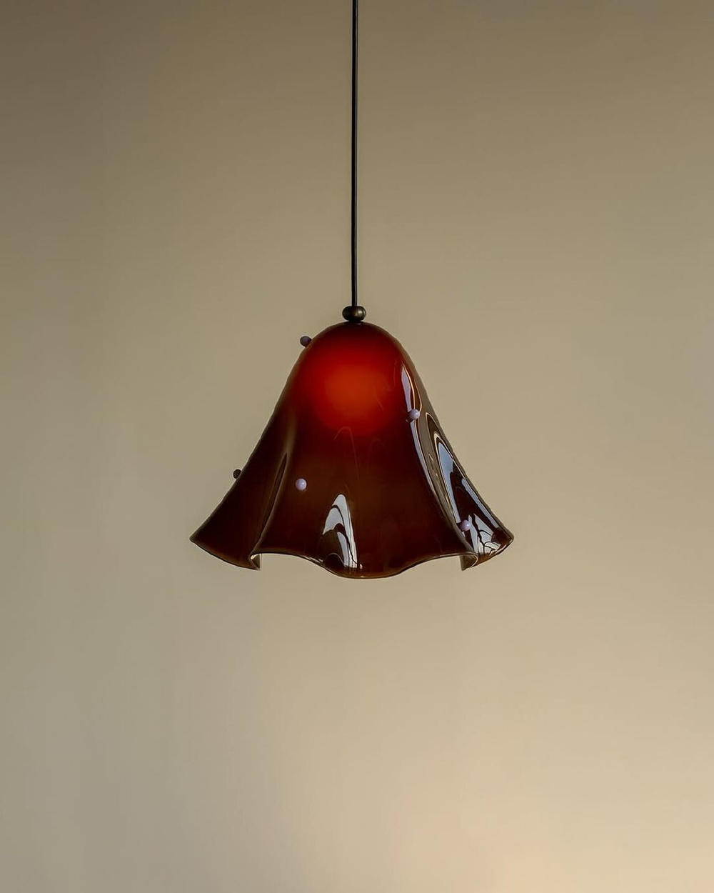 Эти подвесные светильники выполнены из гладкого, глянцевого стекла и имеют мягкую, волнообразную форму, напоминающую расплавленную ткань.