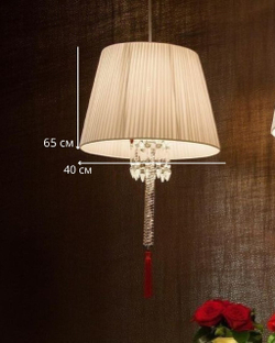 Изысканное люстра Baccarat с белым плиссированным абажуром, хрустальной ножкой и акцентной красной кистью.