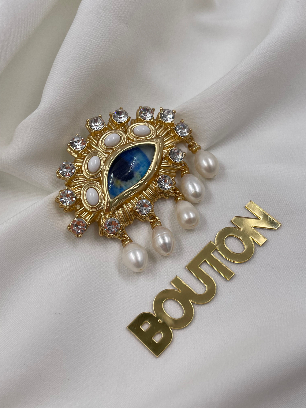 Брошь Скиапар. золотистое в форме голубого глаза с жемчугами и стразами