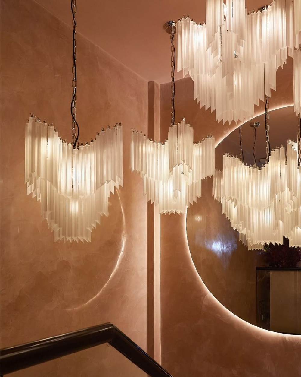 Изысканная каскадная люстра с вытянутыми стеклянными элементами и декоративной потолочной розеткой.