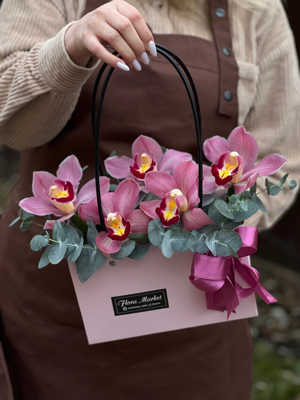 Композиция из орхидеи цимбидиум и эвкалипта в элегантной сумочке