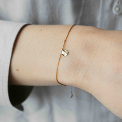 браслет «мятый лист» из желтого золота на бежевой нити